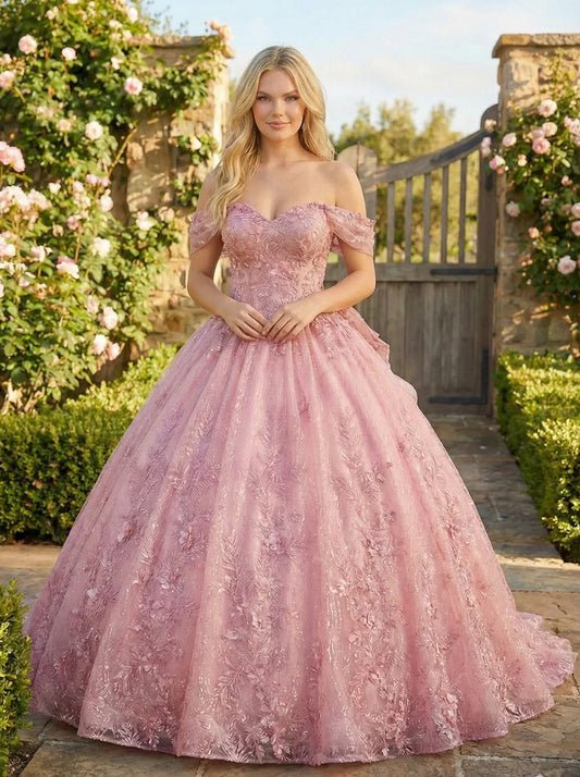Woman in pink off-shoulder embroidered ball gown dress standing in a garden